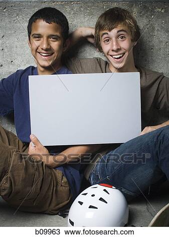 Portrait of two teenage boys holding a blank sign and smiling View Large Photo Image Stock Image - Portrait of two teenage boys holding a blank sign and smiling. Fotosearch