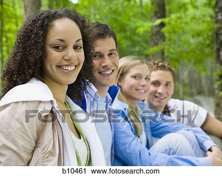 Portrait of two young women and two young men smiling View Large Photo Image Stock Image - Portrait of two young women and two young men smiling. Fotosearch
