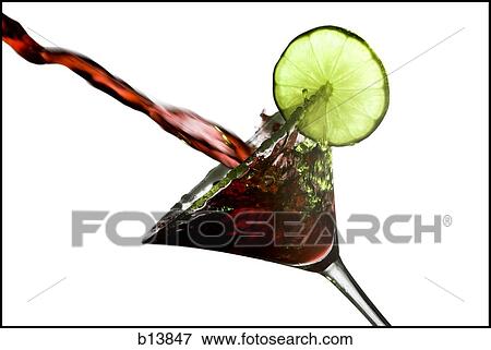 Stock Photo - Pouring martini in glass with lime garnish. Fotosearch