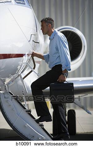 Stock Image - Profile of a businessman entering an airplane. Fotosearch