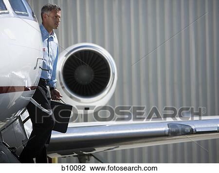 Stock Image - Profile of a businessman exiting an airplane. Fotosearch