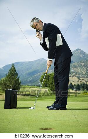 Profile of a businessman playing golf and talking on a mobile phone View Large Photo Image Stock Photograph - Profile of a businessman playing golf and talking on a mobile phone. Fotosearch