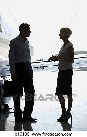 Profile of a businesswoman and a businessman standing near an airplane and talking View Large Photo Image Stock Image - Profile of a businesswoman and a businessman standing near an airplane and talking. Fotosearch