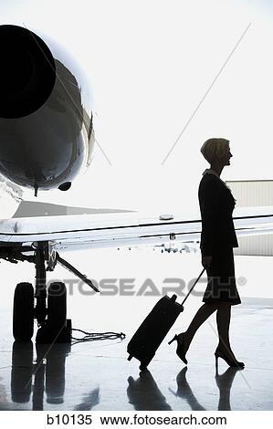 Profile of a businesswoman pulling a suitcase View Large Photo Image Stock Photography - Profile of a businesswoman pulling a suitcase. Fotosearch