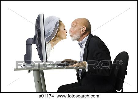 Profile of a senior man kissing a senior woman emerging from a computer monitor View Large Photo Image Picture - Profile of a senior man kissing a senior woman emerging from a computer monitor. Fotosearch