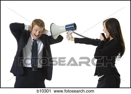 Stock Image - Profile of a teenage girl shouting in a megaphone with a businessman covering his ears. Fotosearch