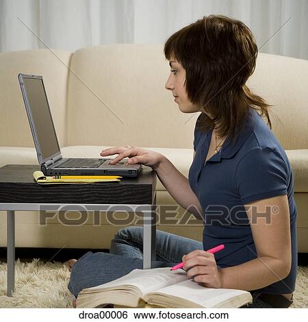 Stock Photograph - Profile of a teenage girl using a laptop. Fotosearch