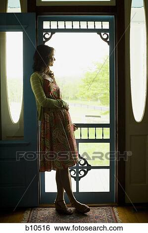 Profile of a woman leaning against a door and looking away View Large Photo Image Stock Photograph - Profile of a woman leaning against a door and looking away. Fotosearch