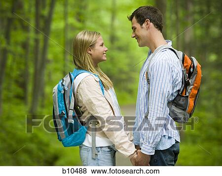 Stock Photo - Profile of a young couple looking at each other and smiling. Fotosearch