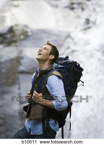 Profile of a young man carrying a backpack View Large Photo Image Stock Image - Profile of a young man carrying a backpack. Fotosearch