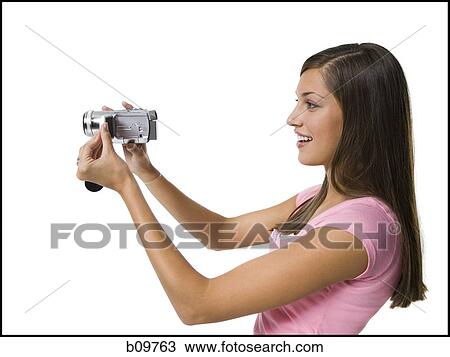 Profile of a young woman holding a video camera View Large Photo Image Stock Image - Profile of a young woman holding a video camera. Fotosearch