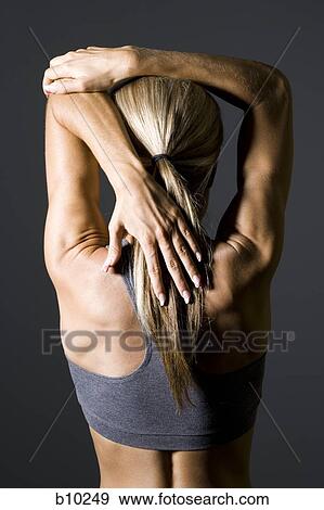 Rear view of a young woman exercising View Large Photo Image Stock Photo - Rear view of a young woman exercising. Fotosearch