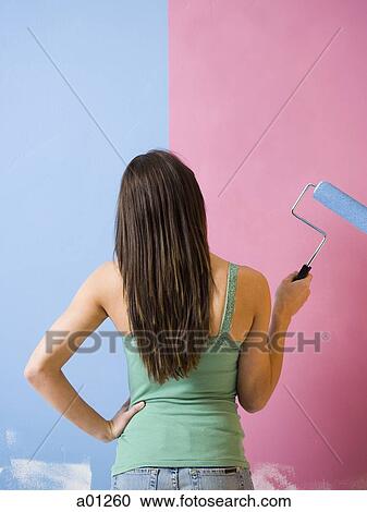Rear view of woman painting wall with a paint roller View Large Photo Image Stock Image - Rear view of woman painting wall with a paint roller. Fotosearch