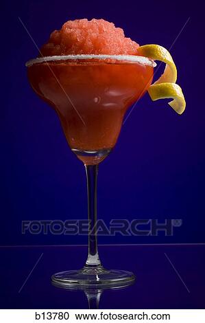 Stock Image - Red slush beverage in cocktail glass with lemon garnish. Fotosearch