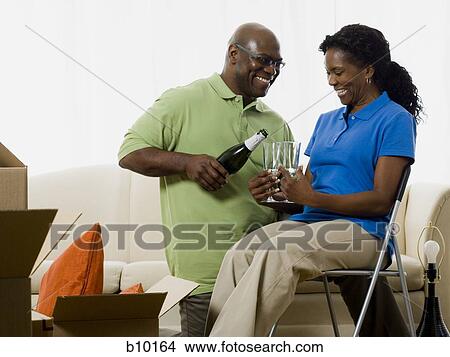 Picture - Senior man pouring champagne into champagne flutes. Fotosearch