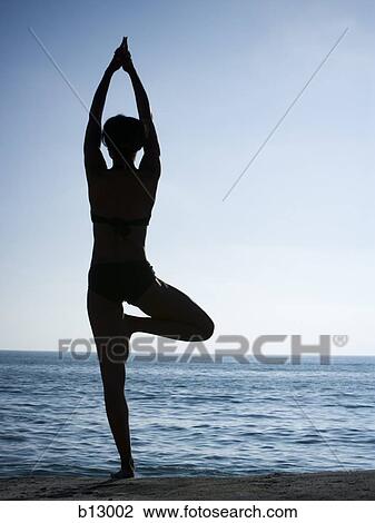 Silhouette of a woman exercising on a beach View Large Photo Image Stock Image - Silhouette of a woman exercising on a beach. Fotosearch