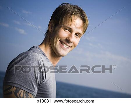 Smiling man on beach View Large Photo Image Stock Image - Smiling man on beach. Fotosearch