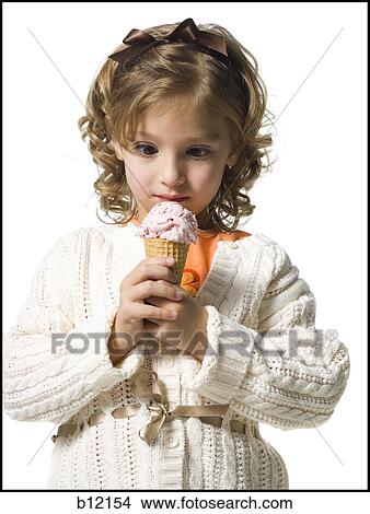 Smiling young girl in white sweater eating ice cream cone View Large Photo Image Picture - Smiling young girl in white sweater eating ice cream cone. Fotosearch