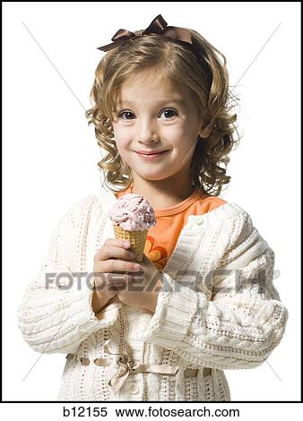 Stock Photography - Smiling young girl in white sweater eating ice cream cone. Fotosearch