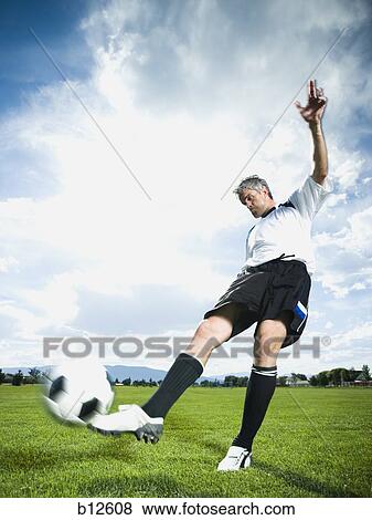 Stock Photo - Soccer player kicking ball. Fotosearch