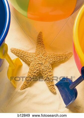 Stock Photo - Starfish sand pail and beach toys. Fotosearch