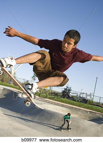 Teenage boy jumping with a skateboard View Large Photo Image Stock Photo - Teenage boy jumping with a skateboard. Fotosearch