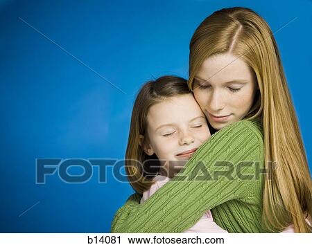 Teenage girl and young girl hugging View Large Photo Image Stock Image - Teenage girl and young girl hugging. Fotosearch