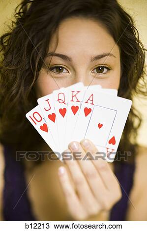 Stock Image - Teenage girl playing poker holding straight flush. Fotosearch