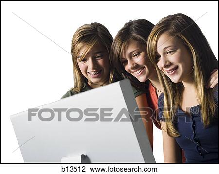 Three girls looking at computer monitor smiling View Large Photo Image Stock Image - Three girls looking at computer monitor smiling. Fotosearch