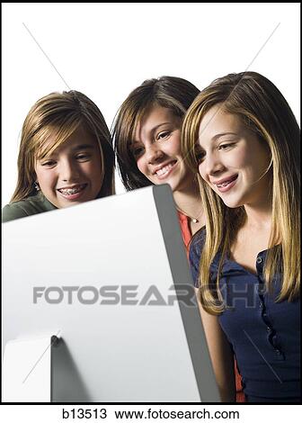 Three girls looking at computer monitor smiling View Large Photo Image Stock Image - Three girls looking at computer monitor smiling. Fotosearch