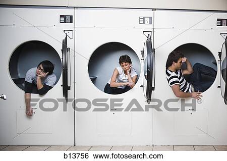Three people in dryers at Laundromat waiting View Large Photo Image Stock Photograph - Three people in dryers at Laundromat waiting. Fotosearch