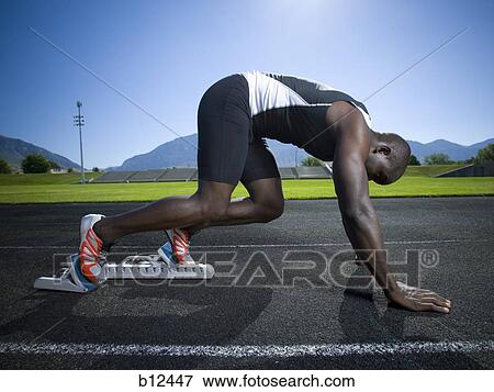 Track runner in starting position ready to race View Large Photo Image Stock Photo - Track runner in starting position ready to race. Fotosearch