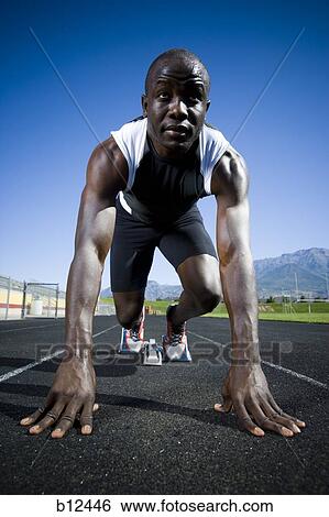 Track runner in starting position ready to race View Large Photo Image Stock Photograph - Track runner in starting position ready to race. Fotosearch