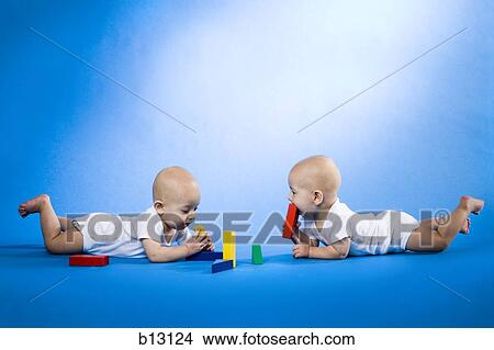 Twin babies on bellies with blocks View Large Photo Image Picture - Twin babies on bellies with blocks. Fotosearch
