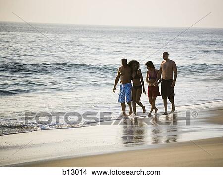 Two couples walking on a beach View Large Photo Image Picture - Two couples walking on a beach. Fotosearch