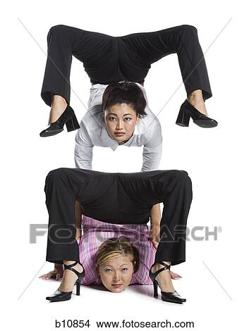 Two female contortionist businesswomen View Large Photo Image Picture - Two female contortionist businesswomen. Fotosearch