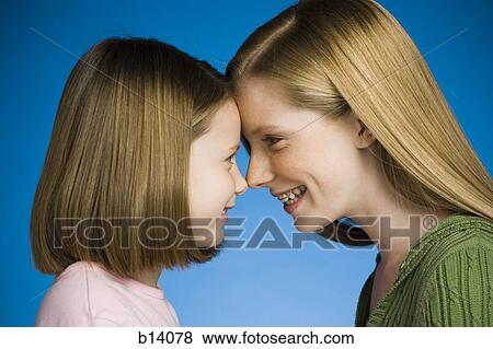 Two girls face to face smiling View Large Photo Image Stock Photo - Two girls face to face smiling. Fotosearch