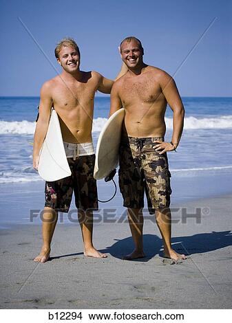 Two males on beach with their surf boards View Large Photo Image Picture - Two males on beach with their surf boards. Fotosearch