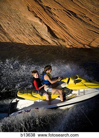 Two people on personal water craft with rock formations View Large Photo Image Stock Photo - Two people on personal water craft with rock formations. Fotosearch