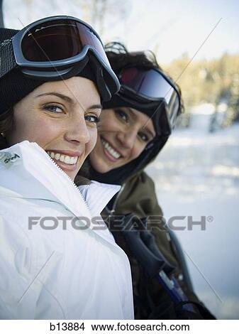Two women outdoors in winter with ski goggles smiling View Large Photo Image Picture - Two women outdoors in winter with ski goggles smiling. Fotosearch