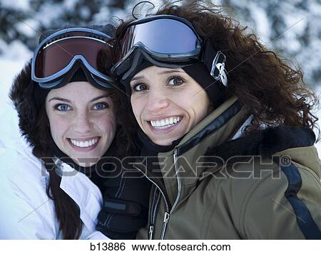 Two women outdoors in winter with ski goggles smiling View Large Photo Image Stock Photograph - Two women outdoors in winter with ski goggles smiling. Fotosearch