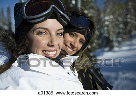 Two women outdoors in winter with ski goggles smiling View Large Photo Image Stock Photography - Two women outdoors in winter with ski goggles smiling. Fotosearch