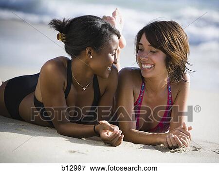 Two women relaxing on a beach View Large Photo Image Stock Photo - Two women relaxing on a beach. Fotosearch