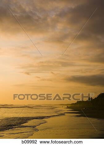 View of a beach at dusk View Large Photo Image Stock Image - View of a beach at dusk. Fotosearch