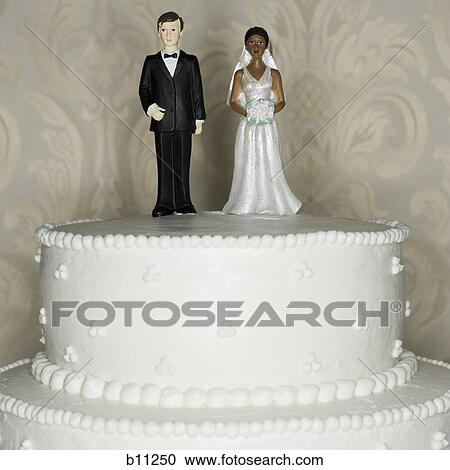 Stock Image - Wedding cake visual metaphor with figurine cake toppers. Fotosearch