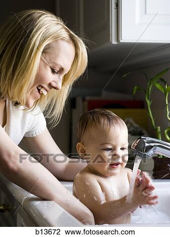 Woman bathing baby in sink View Large Photo Image Stock Image - Woman bathing baby in sink. Fotosearch