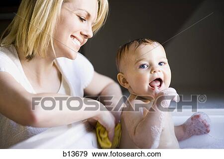 Woman bathing baby in sink View Large Photo Image Stock Photo - Woman bathing baby in sink. Fotosearch