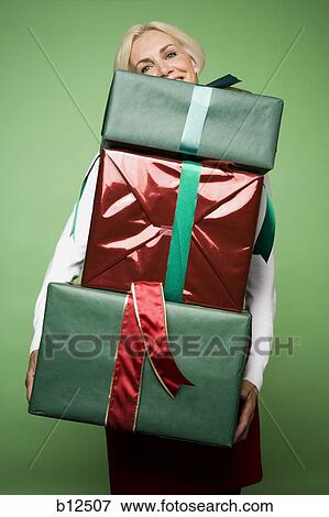 Woman carrying Christmas presents View Large Photo Image Stock Photo - Woman carrying Christmas presents. Fotosearch