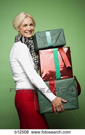 Woman carrying Christmas presents View Large Photo Image Stock Photo - Woman carrying Christmas presents. Fotosearch