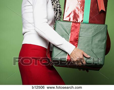 Woman carrying Christmas presents View Large Photo Image Stock Photograph - Woman carrying Christmas presents. Fotosearch